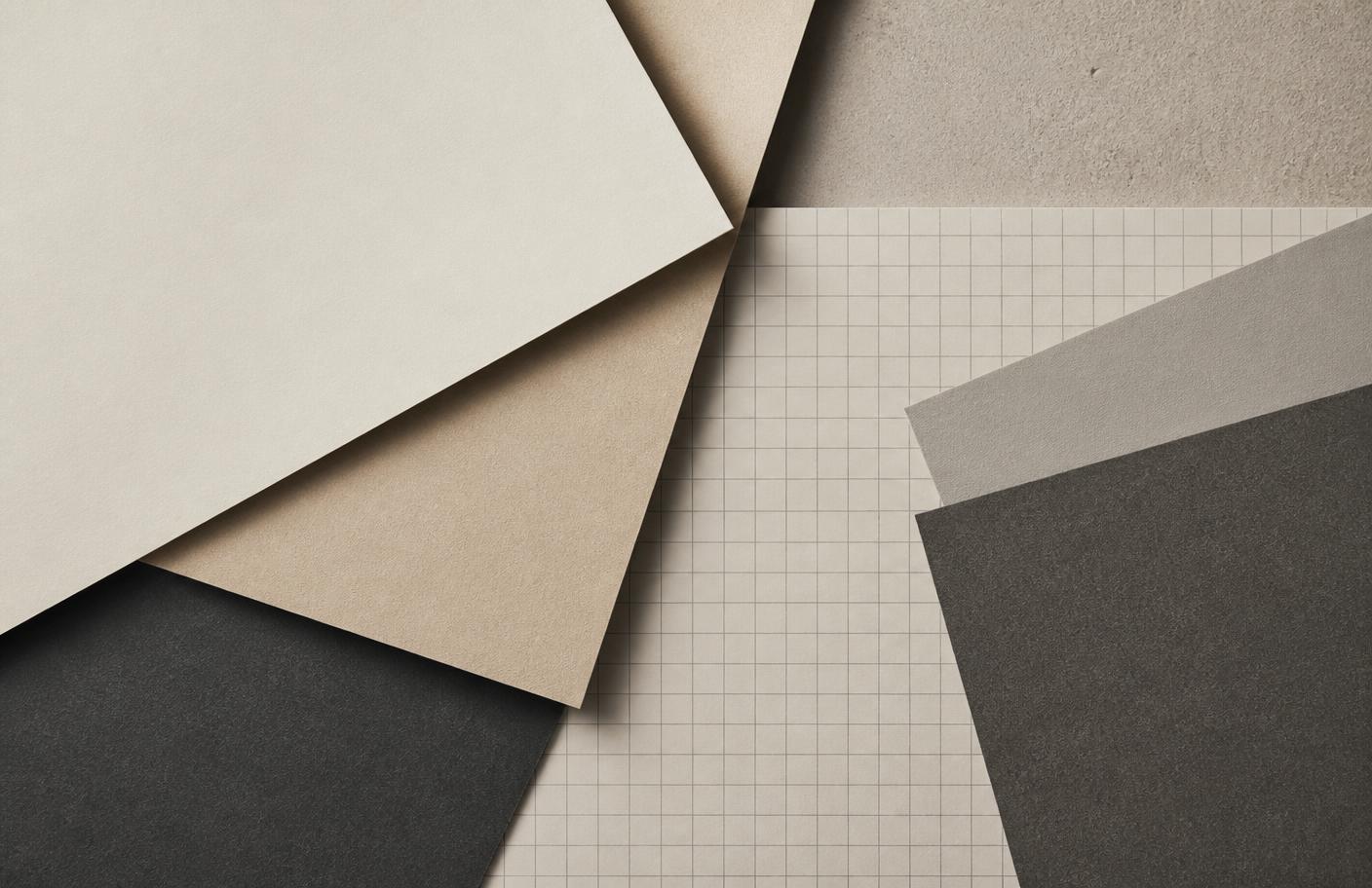 Overhead composition of layered paper sheets and graph paper in sand and graphite tones